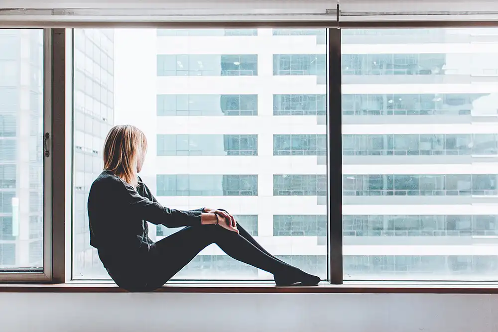 lady sitting behine double glazed windows.